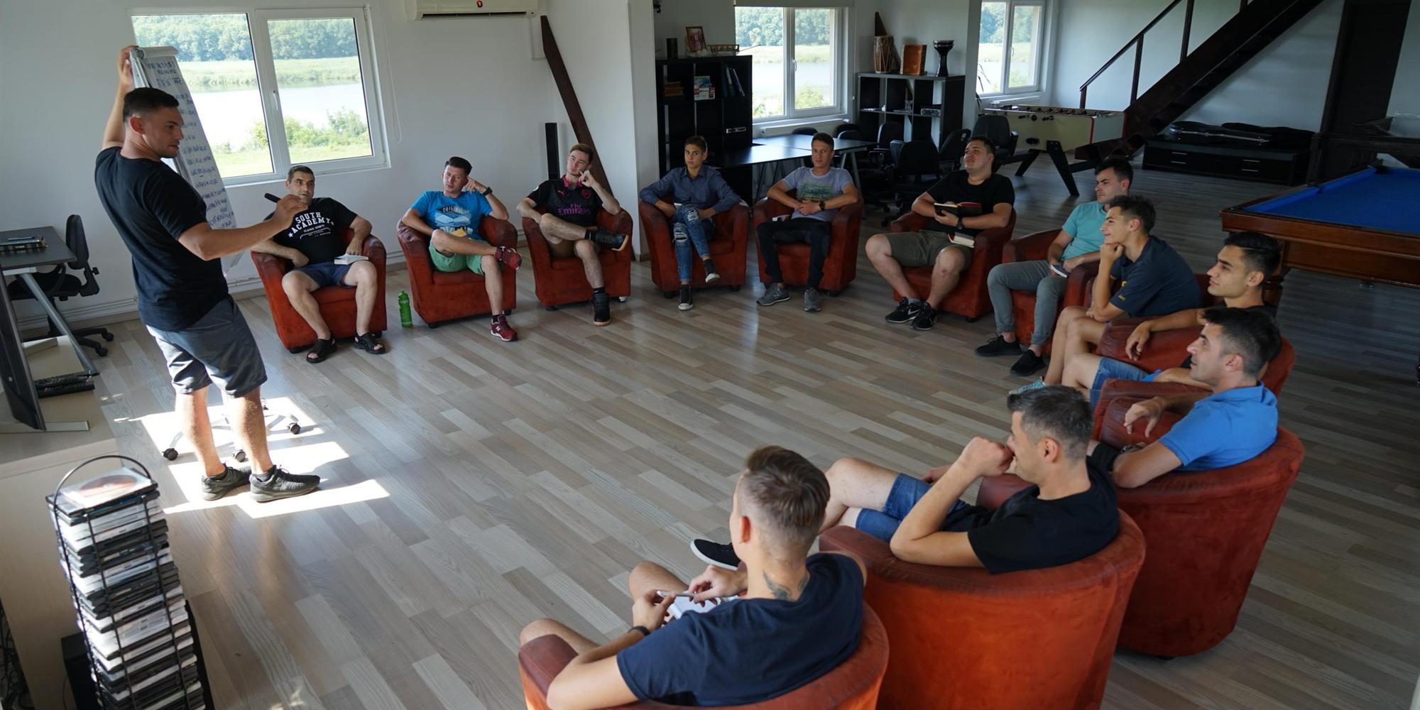 Cerc de discuție într-un centru Teen Challenge — fotolii așezate în cerc, cineva vorbește în fața grupului