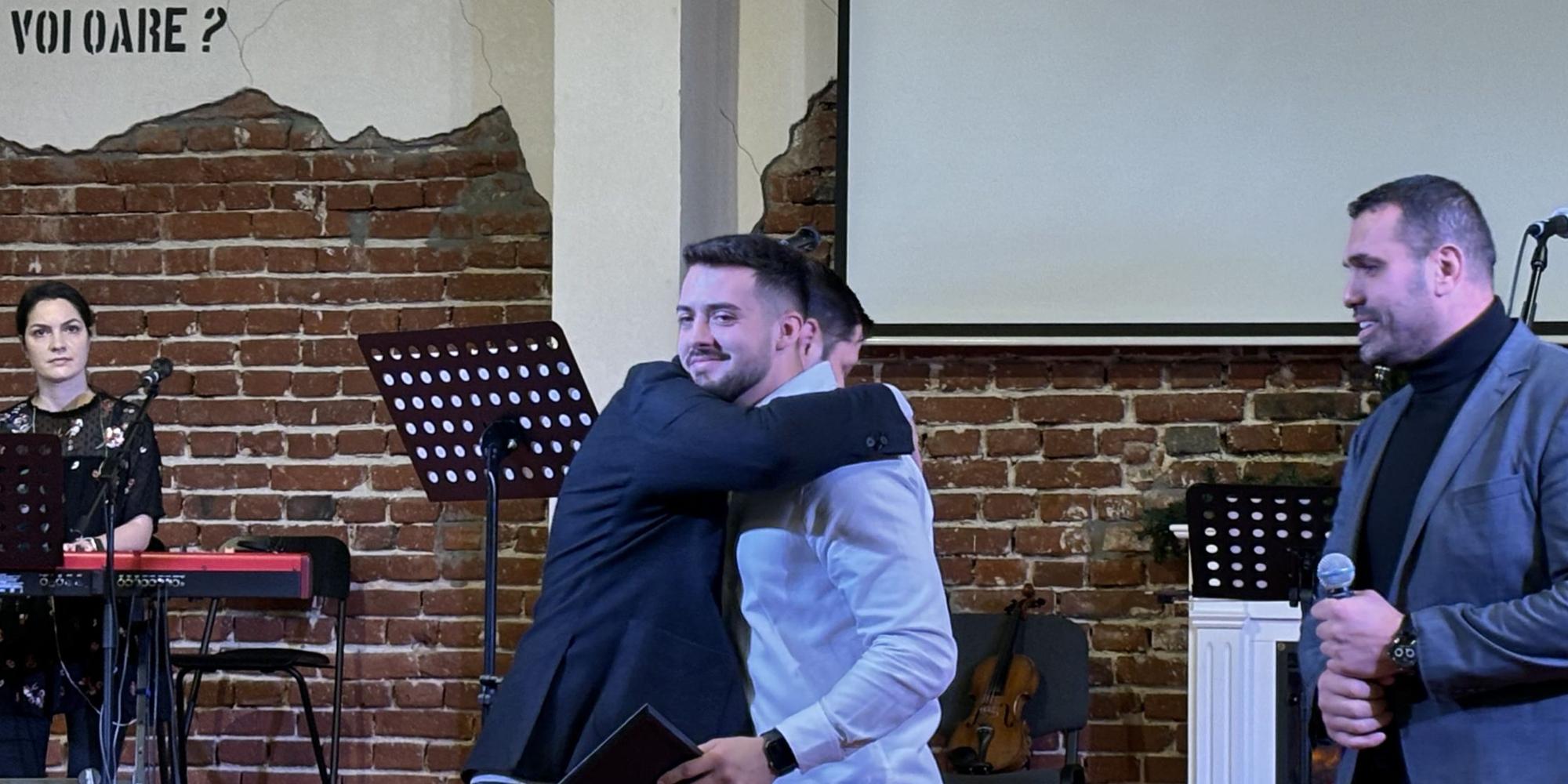 Îmbrățișare pe scenă, la o ceremonie de absolvire Teen Challenge